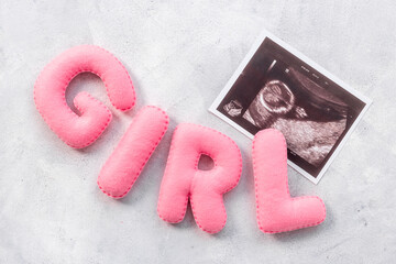 Ultrasound scan of unborn baby with letters girl