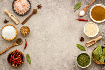 Colorful herbs and spices in bowls for cooking. Pepper chili, laurel leaf, salt and curry
