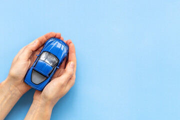 Car insurance concept. Toy car in hands, top view