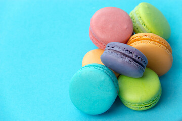 Close-up of macarons cakes of different colors in blue background. Culinary and cooking concept. Tasty colourful macaroons.