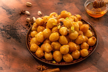 Turkish lokma, a traditional sweet in honey. Bright background.