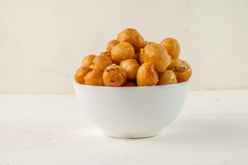 White cup of deep fried dough. Arabic sweet Loukoumades.