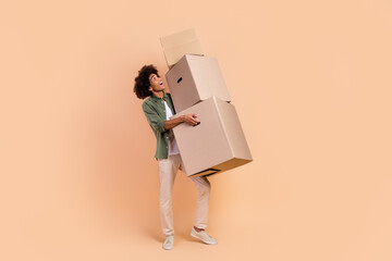 Full length body size view of attractive cheerful wavy-haired guy carrying office boxes isolated...