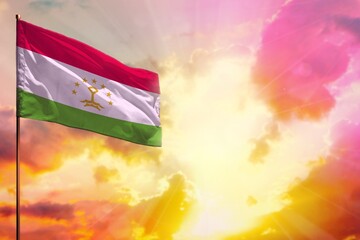 Fluttering Tajikistan flag in top left corner mockup with the space for your text on beautiful colorful sunset or sunrise background.