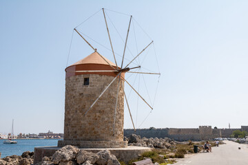 Fototapeta na wymiar The medieval windmills in Mandraki harbour in Rhodes, Greece