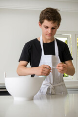 A Teenage Boy Cooking In A Kitchen