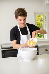 A Teenage Boy Cooking In A Kitchen