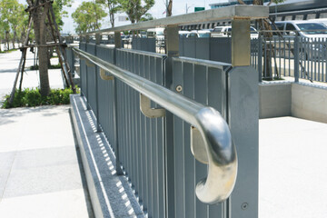 Stainless steel railing structure installed on metal fence in the park.