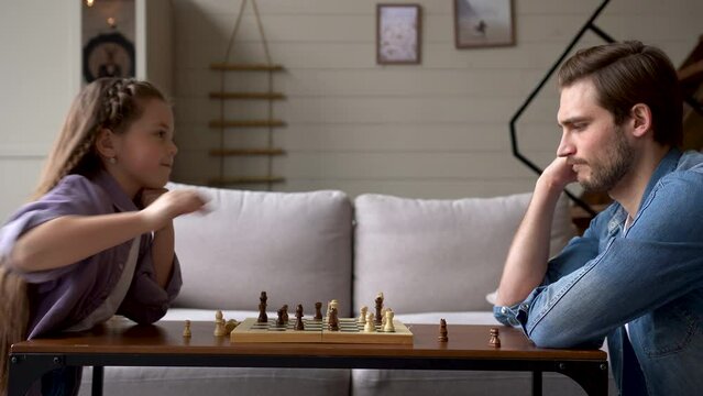 Daughter and Father Playing Chess at Home Family Time Teaching How to Play Chess.