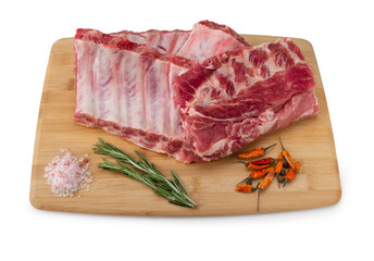 Raw pork ribs with spices, salt and rosemary on wooden background. Fresh raw pork ribs with...