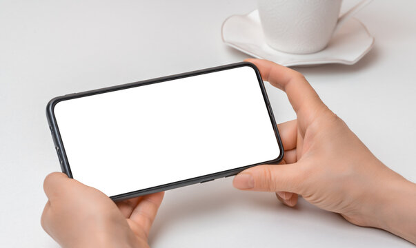 Cropped shot view of woman hands holding cellphone with blank copy space screen for text message or information content, female reading text message
