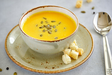 Tasty and healthy dietary food. Pumpkin soup cream on a gray background