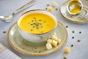 Tasty and healthy dietary food. Pumpkin soup cream on a gray background