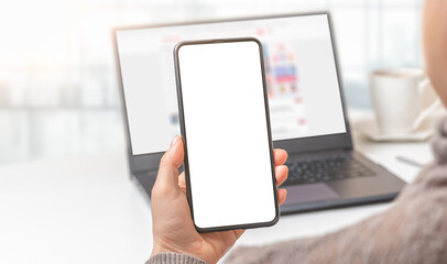 Mockup cellphone. Woman hand holding mobile phone with blank screen in modern office. hand holding smartphone with white screen in office