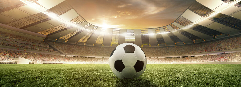 Traditional soccer football ball on grass of football field at stadium with spotlight. Concept of sport, art, energy, power