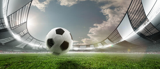 Soccer football ball jumping on green grass of football field at crowded stadium with spotlight....