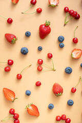Naklejka na ściany i meble Pattern with strawberries, cherries and raspberries on an orange background