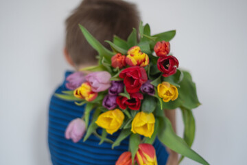a boy with a big bouquet of flowers, tulips