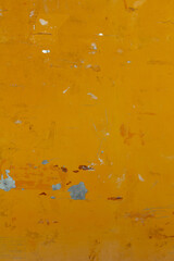 Texture of an orange wall with scuffs and peeling paint, vertical format