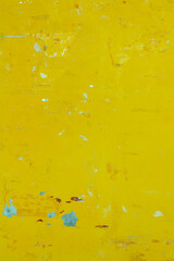 Texture of a yellow wall with scuffs and peeling paint, vertical format
