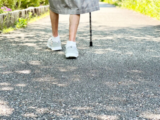 杖をついて歩く高齢女性の足