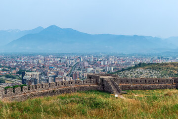 The remains of the fortress wall of Rozafa Castle against the backdrop of the city panorama of Shkoder, Albania. Beautiful town landscape among the mountains
