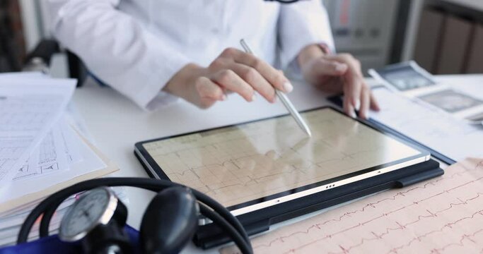 Cardiologist examines electrocardiogram on tablet in cardiology clinic