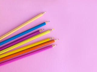 Colorful pencils with copy space on pink  background 