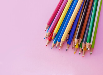 Colorful pencils with copy space on pink  background 