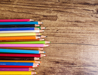 Fototapeta premium Colorful pencils with copy space on wooden background 
