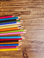 Colorful pencils with copy space on wooden background 