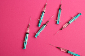 Medical syringe on a pink background. A syringe for injection. The concept of health and beauty