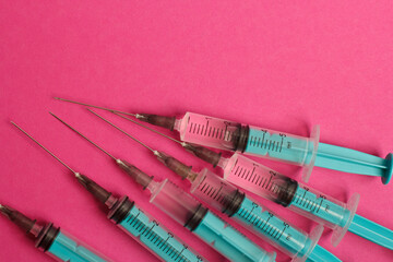 Medical syringe on a pink background. A syringe for injection. The concept of health and beauty