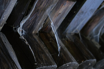 close-up of brown logs of construction with old paint, natural wood texture, dark frame with cobwebs, wallpaper, building material, background for designer with copy space