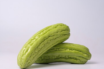 Organic Bitter melon or fresh Momordica charantia on white background. (Scientific name: Momordica charantia L.) Bitter gourd has large fruit, green color, rough skin, bitter taste. (in melon family).