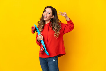 Young caucasian woman isolated on yellow background with a skate with happy expression