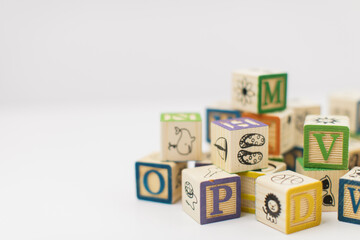 A pile of children painted alphabet wooden blocks isolated with white background for text copy space. 