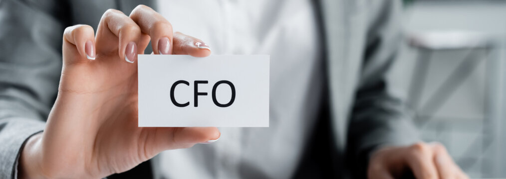 cropped view of woman holding paper with cfo lettering in office, banner.