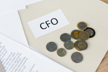 top view of paper with cfo lettering near coins and documents.