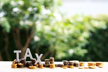 Tax word with coin on tree nature background