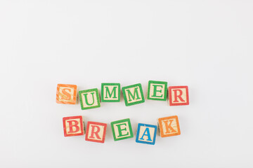 An arrangement of children painted alphabet wooden blocks spelling out "summer" isolated in a white background with text copy space. 