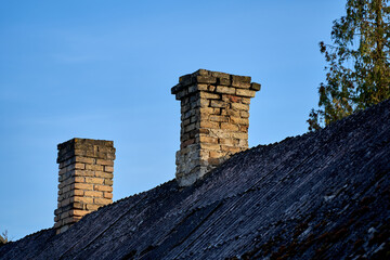 An old brick chimney against the blue sky.