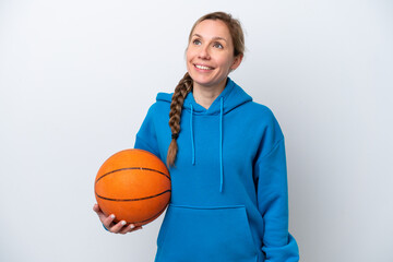 Young caucasian woman playing basketball isolated on white background thinking an idea while looking up