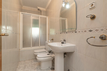 Bathroom with mirror with glass shelf, porcelain sink with foot of the same material and shower cabin with white folding screen