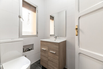 Fototapeta na wymiar Bathroom with wooden furniture, square frameless mirror, porcelain sink and white painted solid wood door