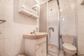 wc with white wooden bathroom cabinet with mirror, pink porcelain sanitary ware and square shower cabin with screen