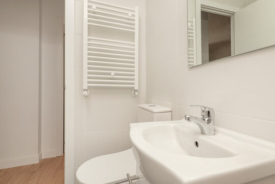 toilet with white wooden bathroom cabinet with frameless mirror, shower cabin with screen and wall tiled with hydraulic tiles