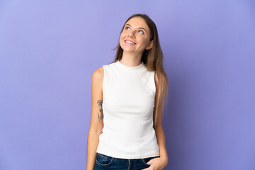 Young Lithuanian woman isolated on purple background thinking an idea while looking up