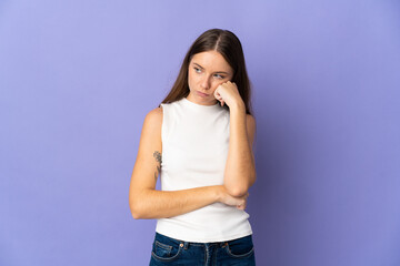 Young Lithuanian woman isolated on purple background with tired and bored expression