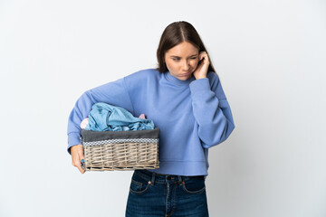 Young Lithuanian woman holding a clothes basket isolated on white background frustrated and...